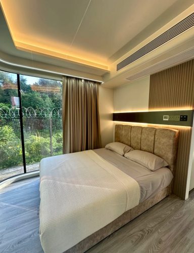 Helles Schlafzimmer mit Doppelbett, großen Fenstern und modernen Akzenten.